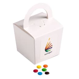 A coloured noodle box containing M&Ms in various colours, placed alongside colourful chocolate beans.