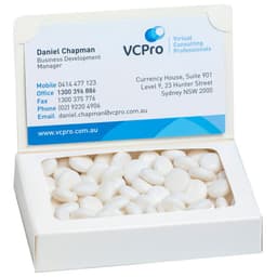 A white box containing mints with a business card inside. The box has a logo.