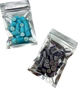 Silver zip lock bags containing blue and purple rock candy pieces. Each bag features a clear design and a branding logo.