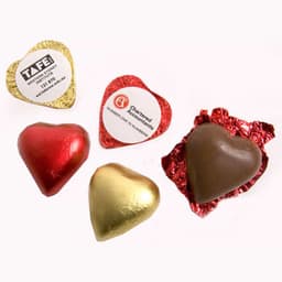 A selection of chocolate hearts in red, gold, and brown foil, featuring various shapes and wrapping.