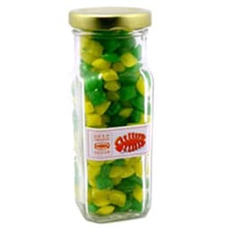 A tall glass jar with a gold lid, filled with green and yellow humbug sweets. The jar features a logo.