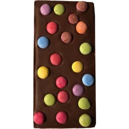 A chocolate bar with a smooth dark brown surface adorned with colourful, round candy spots in pink, blue, green, and yellow.