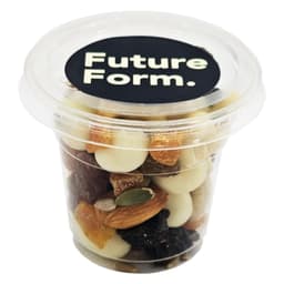 A clear tub filled with a variety of premium trail mix, including nuts, seeds, and dried fruit. It has a black lid with a logo.