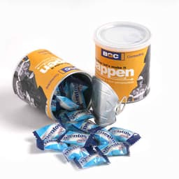A cylindrical container in orange and white, filled with blue Mentos mints, with some mints spilling out.