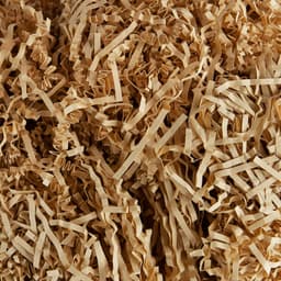 A textured filling consisting of shredded, crinkled kraft paper in various shades of light brown.