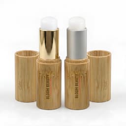Bamboo lip balm sticks in natural wood packaging, featuring a gold and silver twist-up design.