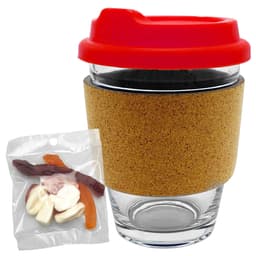 A glass coffee cup with a cork band and a red lid, accompanied by a pack of mixed lollies.
