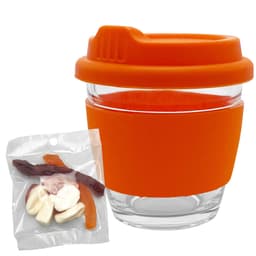 A clear glass coffee cup with an orange silicone lid and sleeve, accompanied by a bag of mixed jelly lollies.