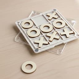 A Tic Tac Toe board game coaster with a clear base, featuring wooden X and O pieces in a grid pattern.
