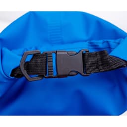 A blue dry sack featuring a black clip buckle and adjustable strap for fastening. It has a smooth, waterproof surface.