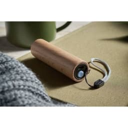 A drink bottle made of wood with a cylindrical shape, featuring a strap and small speaker on the side.