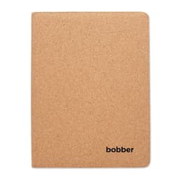 A cork-covered notebook with rounded corners, featuring a small logo in the bottom corner.