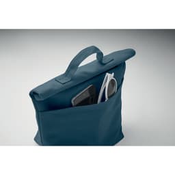 A bag in teal featuring a pocket with a smartphone and sunglasses visible. The bag has a handle on top.