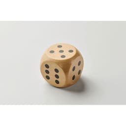 A wooden dice with six sides, each marked with black dots, resting on a light background.
