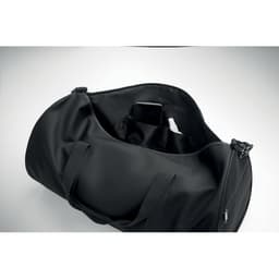 A black duffel bag with a smooth finish and a spacious interior, featuring a compartment for a phone.