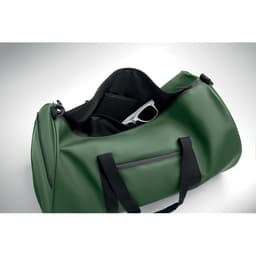 A green duffel bag with black accents, featuring an open compartment showing sunglasses inside.