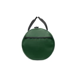 A green round bag with a black strap, featuring a textured surface and a zippered pocket on the front.