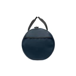 A round navy blue bag with a textured surface and a black strap. The bag features a top closure and a front pocket.