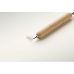 A wooden rolling pin with a metal tip rests on a light surface, accompanied by a small white silicone cap.