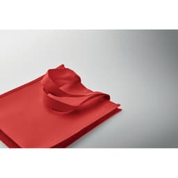A red tote bag with handles, featuring a simple design and a smooth texture. It has a logo on one side.