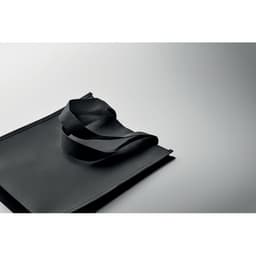 A black tote bag with a sleek design and long handles rests on a simple background.