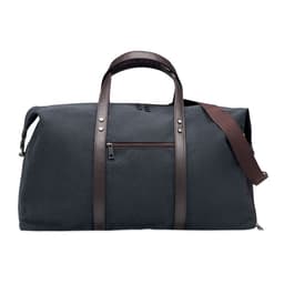 A duffel bag in dark grey fabric with brown leather handles and a detachable shoulder strap. Features a zippered pocket.