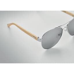 Sunglasses with a silver frame and grey lenses, featuring bamboo-styled arms and a sleek design.