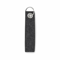 A keyring featuring a textured dark grey fabric loop with a metal ring, designed for attaching keys or accessories.