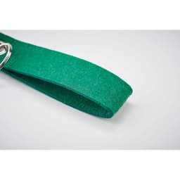 A green felt drink bottle holder with a metal ring attachment. It features a simple, textured design.