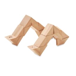 A set of tan geometric blocks arranged in an abstract, angular formation. The blocks have a smooth finish and sharp edges.
