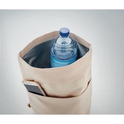 A drink bottle in a beige bag with a pocket for a phone. The bottle is blue and partially visible.