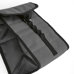 A grey cooler bag with a roll-top closure and a metal G hook. It features sturdy straps and a textured surface.