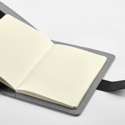 A grey A5 folder featuring a notepad with cream-coloured pages and a black closure strap.