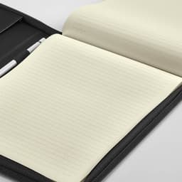 A black A4 folder with a zipper closure, featuring a notepad with lined pages and a pen holder.
