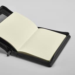 A black zipped folder featuring a lined notepad with cream pages inside. Includes a pocket for storage.