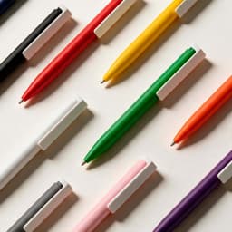 A collection of pens in various colours including black, red, yellow, green, orange, pink, and purple with white accents.