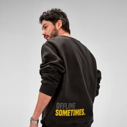 A dark crew neck sweatshirt featuring rolled sleeves and a logo. The back has text in yellow reading "OFFLINE SOMETIMES."