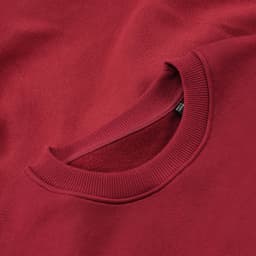 A burgundy crew neck sweatshirt featuring a ribbed neckline and a logo. Made from organic cotton and rPET.