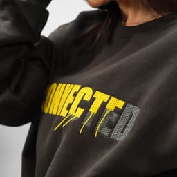 A crew neck sweatshirt in dark grey with a yellow and grey graphic design. It features a logo on the front.
