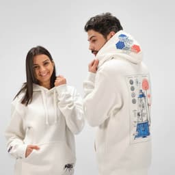 A cream hooded sweatshirt featuring a logo and a colourful graphic on the back. Made from organic cotton and recycled materials.