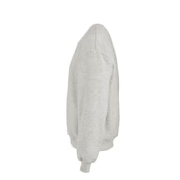 A grey oversized sweatshirt with a crew neck and ribbed cuffs. It has a logo on the garment.