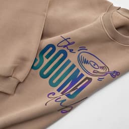 A beige oversized sweatshirt featuring multicoloured graphics and a logo. Made from organic cotton and rPET.