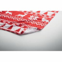 A festive red blanket featuring white reindeer and snowflake patterns, with a soft, fluffy lining.