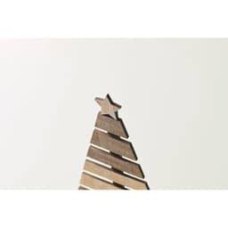 A decorative wooden Christmas tree, featuring layered sections and a star on top, displayed against a light background.