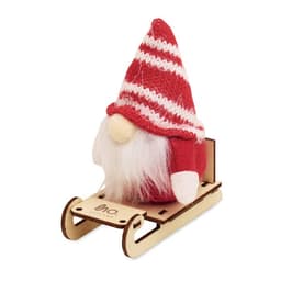 A gnome figure with a red and white knitted hat and white beard sitting on a wooden sleigh.