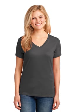 A woman stands wearing a dark grey V-neck T-shirt made of cotton, paired with blue jeans. The shirt features a logo.