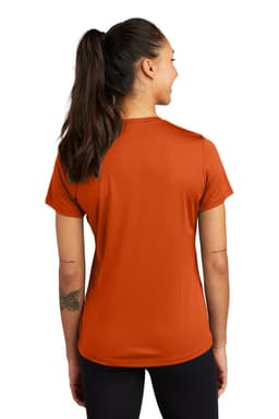 A woman wearing an orange Sport-Tek Ladies PosiCharge Competitor Tee, viewed from the back. The shirt features a logo.