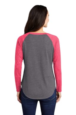 A long sleeve tri-blend tee featuring a grey body and pink raglan sleeves, with a rounded hem and a logo.