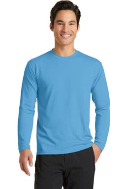 A man wearing a bright blue long sleeve performance blend tee, standing with a smile. The shirt features a logo.