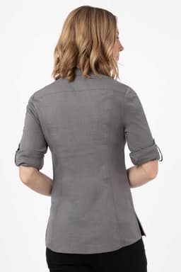 A grey women's shirt with rolled-up sleeves, featuring a fitted design and a logo on the back.